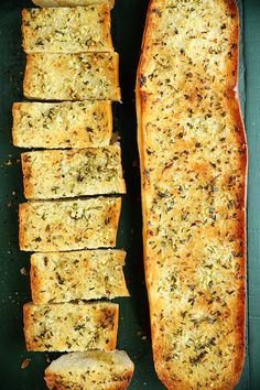 sliced bread with herbs on it sitting in a green box next to slices of bread