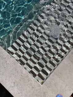 a checkered tile floor next to a swimming pool