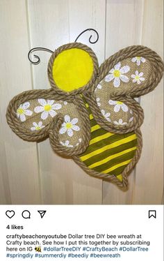 an image of a stuffed bee hanging on a door handle that is decorated with burlocks and daisies