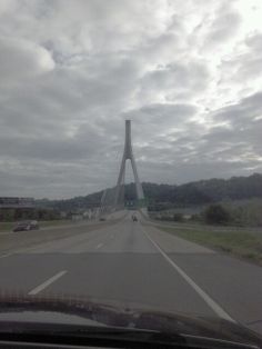 a view from the inside of a car looking at a tall bridge in the distance