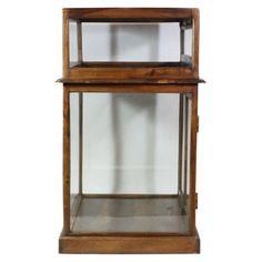 an old wooden display case with glass front and bottom shelves on each side, against a white background