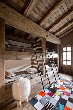 a room with bunk beds and rugs on the floor in front of it,