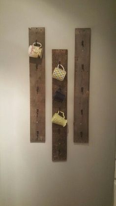 two wooden boards mounted to the wall with purses and bags hanging on them,