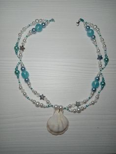 a necklace with shells and pearls on it