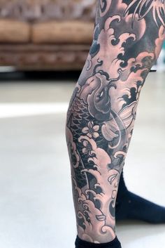 a man's leg with tattoos on it