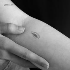 a person with a small tattoo on their left arm, holding onto the other hand