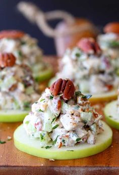 some food is sitting on top of small slices of apple halves with pecans in the background