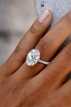 a woman's hand with a diamond ring on her finger and an engagement band