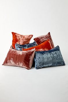 four velvet pillows stacked on top of each other