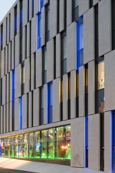 a large building with many windows and blue lights on the side of it's face