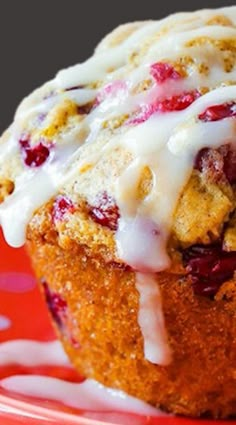 a close up of a muffin on a plate with icing and strawberries