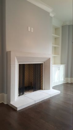 an empty living room with a fireplace in it