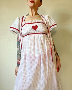 "Sweet Heart. Beautiful Deadstock Vintage 1970's/1980's Lanz of Salzburg red and white 2pc nightie set with heart appliqué, heart buttons, polka dots galore and lace trim. Perfect sweetheart ensemble. ♥️♥️♥️ Marked a vintage size M  Fits XS/S/M (I'm about a M), but please use measurements as fit guide.  Robe: 13.75\" shoulder  23\" bust (on the half) 8\" sleeve  56.25\" length  Unlined  Center front heart button closures and tie at neck  Cotton or cotton/blend  Flutter sleeve  Front patch pockets  Lace trim gathering at forward shoulder  Back yoke with gathering  Contrast polka dot binding  Nightgown: 15.5\"-19\" bust (on the half)  55\" length  Unlined  Slip on style  Cotton or cotton/blend  Attached tie at underbust  Elastic back  Lace trim  Heart appliqué at bust  Contrast polka dot bin White Fitted Nightgown For Hospital, White Fitted Dress For Pajama Party, Fitted White Nightgown For Hospital, Vintage Dresses For Pajama Party, Retro Fitted Sleepwear For Loungewear, Fitted Retro Sleepwear For Loungewear, Fitted Cotton Nightgown For Hospital, Fitted Vintage Sleepwear For Sleepover, Fitted Retro Summer Sleepwear