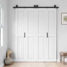 an empty room with two white doors and a bench in the corner next to it