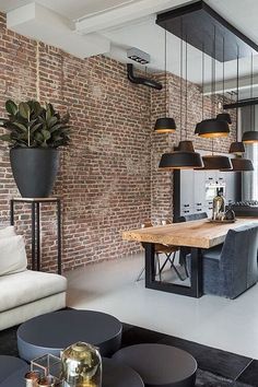 a living room filled with furniture next to a brick wall and floor covered in lots of windows