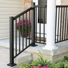 an iron railing on the front steps of a house with potted plants and flowers