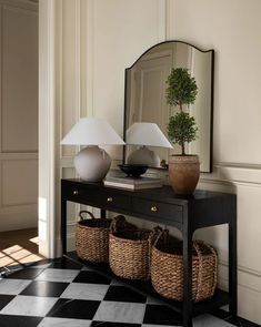 a black and white checkered floor with a table, lamp and basket on it