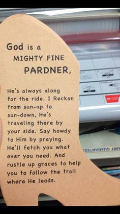 someone is holding up a bookmark that says god is a mighty fine pardner he's always along for this ride, i racken from sun - up