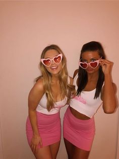 two women wearing heart shaped sunglasses pose for the camera