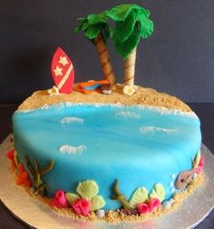 a blue cake decorated with an island and palm tree