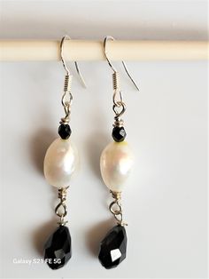 Freshwater pearls and black teardrop swarovski crystals earrings.  These are available in 2 sizes.  1) is 1 1/2 inches in length without moving dangle  2) this earring has a slightly larger and longer pearl and has a teardrop dangle (see pictures)  Both are classic black and white for all occasions.  They are in sterling silver. Perfect gift ideas Black Teardrop Pearl Earrings Gift, Classic Teardrop Crystal Earrings With Pearl Drop, Black Dangle Pearl Earrings For Formal Occasions, Elegant Black Teardrop Pearl Earrings, Black Dangle Pearl Drop Earrings, Black Drop Pearl Drop Jewelry, Black Pearl Drop Dangle Earrings, Classic Black Pearl Drop Earrings, Black Pearl Drop Jewelry