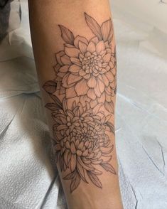 a black and white flower tattoo on the leg