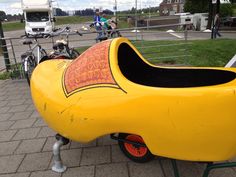 a large yellow boat shaped like a banana sitting on top of a sidewalk