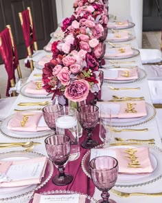 a long table is set with pink and gold place settings