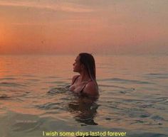 a woman is sitting in the water at sunset with her head above the water's surface