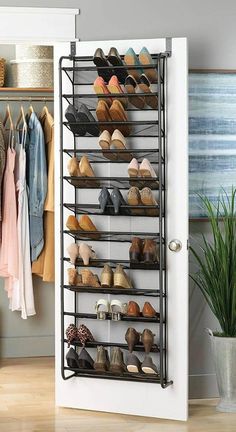 a shoe rack in the corner of a room next to a door with shoes hanging on it