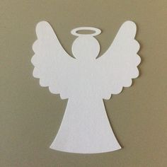 an angel cut out from white paper on a table