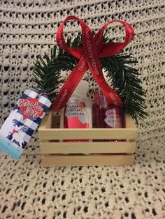 a small wooden crate filled with personal care items and a red ribbon tied around it