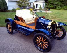 an old blue car parked in front of a house