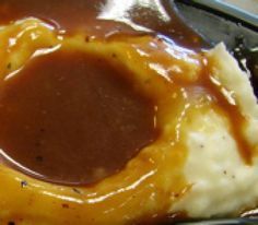 a piece of bread covered in cheese and gravy sitting on top of a table