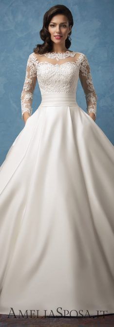 a woman in a wedding dress posing for the camera with her hands on her hips