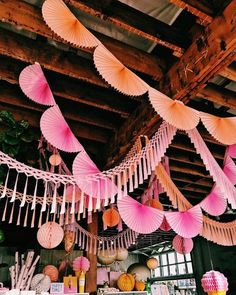 pink paper umbrellas hanging from the ceiling in a room with other decorations and decor items