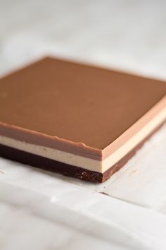 a piece of chocolate sitting on top of white paper