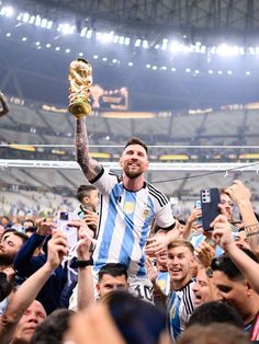 a soccer player is being lifted in the air by his team mates