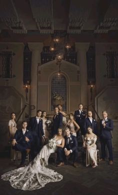 a large group of people posing for a wedding photo