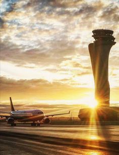 an airplane is parked at the airport as the sun sets