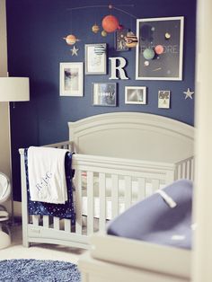 a baby's room with blue walls and pictures on the wall