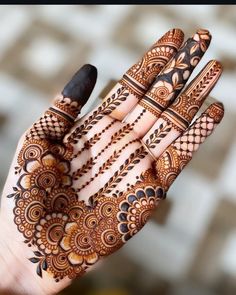 the hand is decorated with henna designs on it