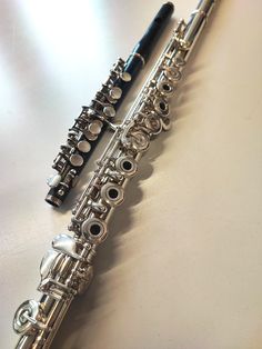 two silver flutes sitting next to each other on a table