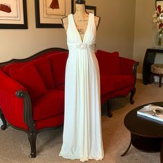 a dress on display in front of a red couch