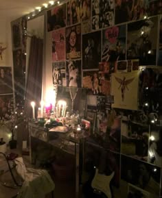 a room filled with lots of pictures and candles on the wall next to a desk