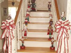 christmas decorations on the banisters and stairs in a home decorated with red ribbons