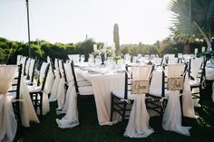 the tables are set with white linens and place settings for guests to sit at