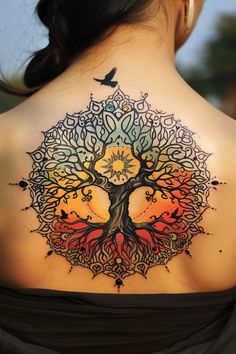 a woman's back with a tree tattoo on it