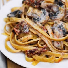 a white plate topped with pasta and mushrooms