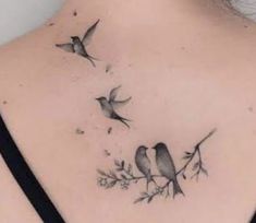 the back of a woman's neck with two birds on it